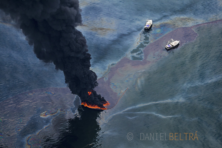 Two ships monitor a controlled burn from oil that was spilled from the wellhead. To aid in clean-up efforts, 5,300 vessels of opportunity were hired from around the area.