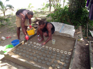 Conservation Assistants Ratu Ewasa Kuribola and Nacanieli Tavaga prepare cement discs used for propagating corals. Image © Reef Explorer Fiji, Ltd.